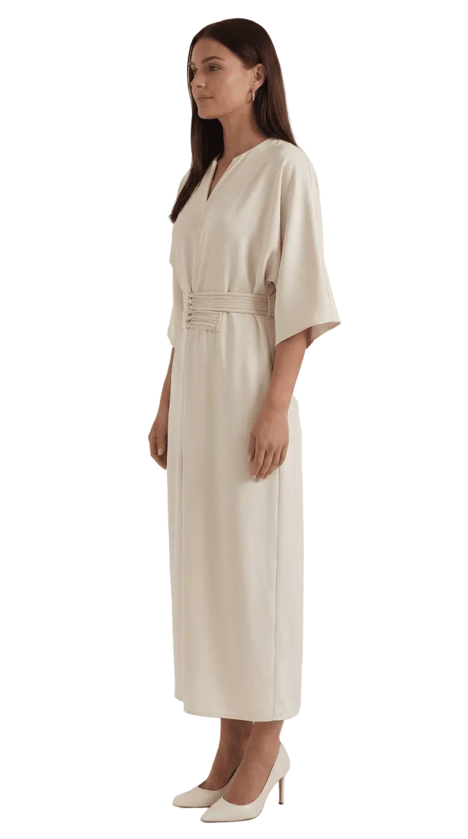 Woman wearing a beige dress with a belt on a white background