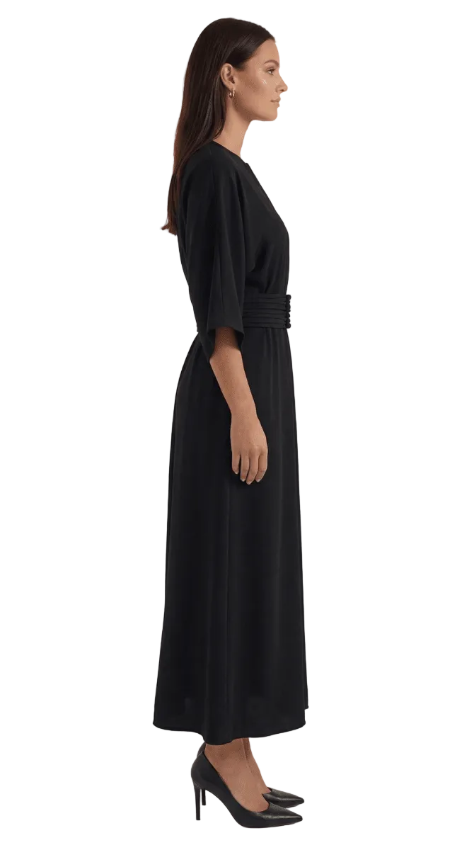 Woman wearing a black dress with a belt on a white background