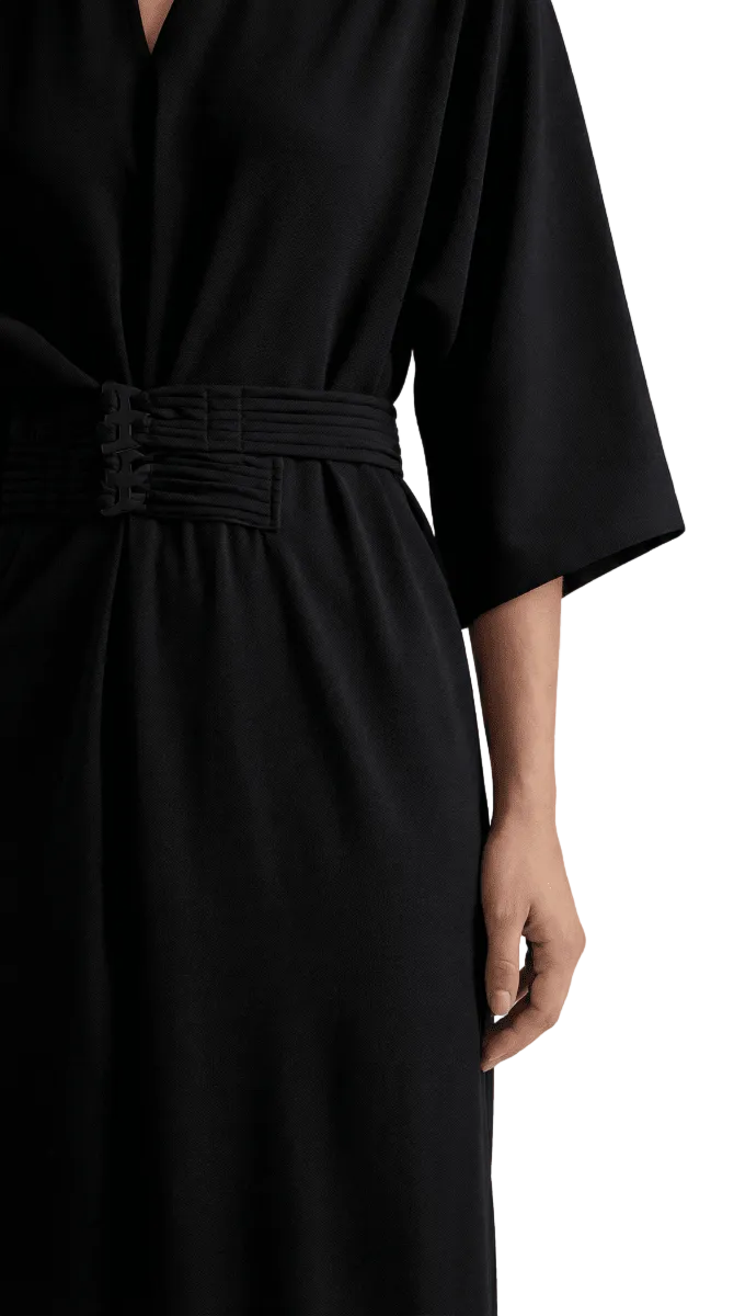 Black dress with a belt on a neutral background