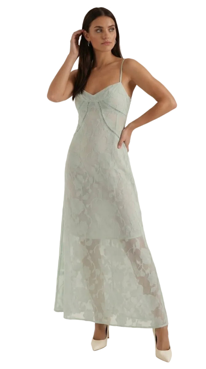 Woman wearing a light green lace dress on a white background