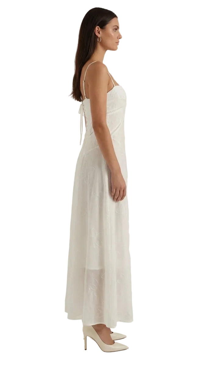 Woman wearing a white dress against a plain background