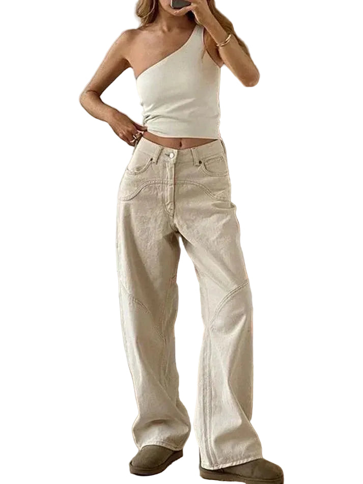 Person wearing a white one-shoulder top and beige pants.
