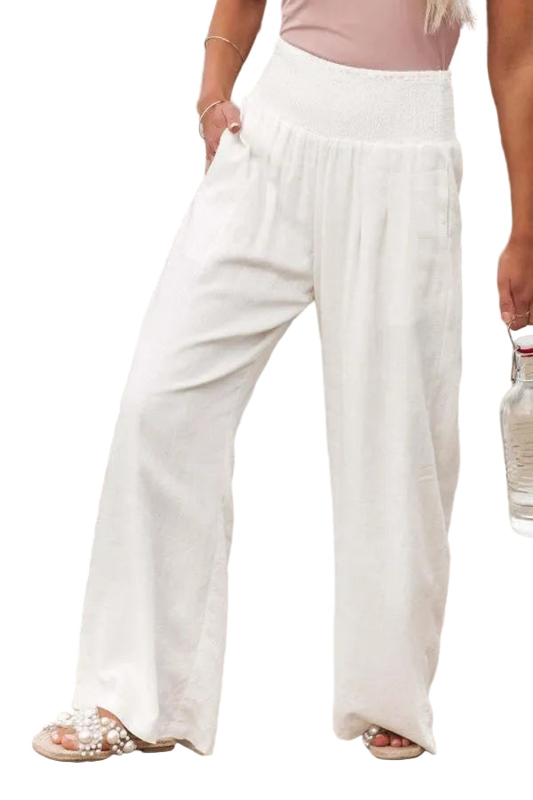 Person wearing white wide-leg pants on a beach.