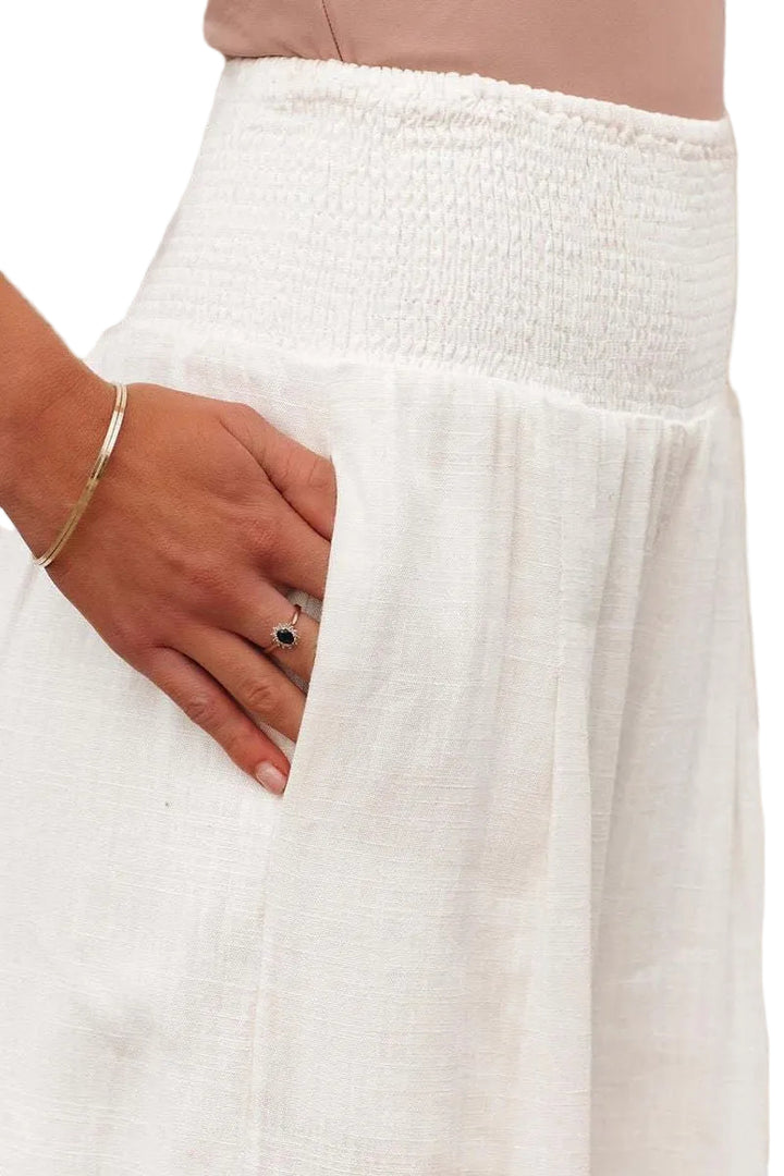 Close-up of a person wearing a white textured skirt with a white background