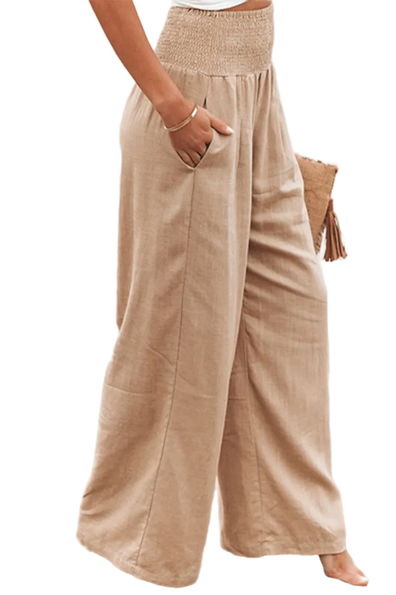 Beige wide-leg pants worn by a person on a beach with a blurred background