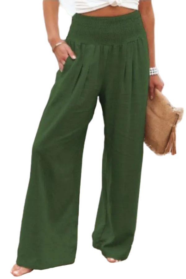 Person wearing green wide-leg pants by a beach.